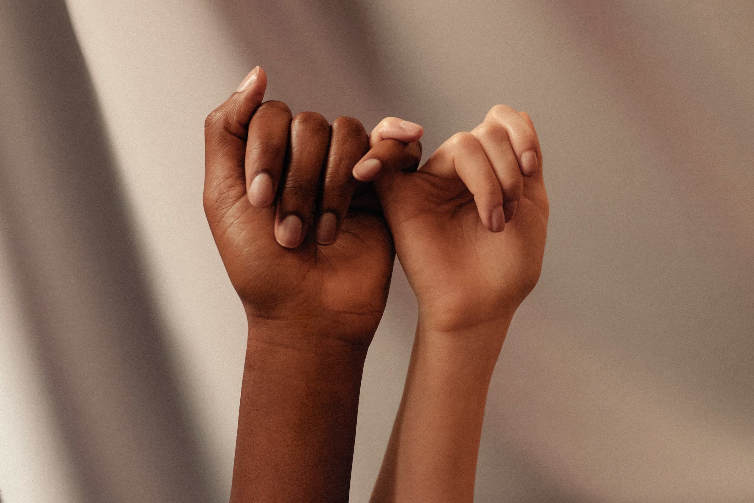 Two people linking little fingers, making a promise.
